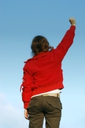 A young woman punches the air, glad to be who she is. Photo: Mateusz Stachowski.